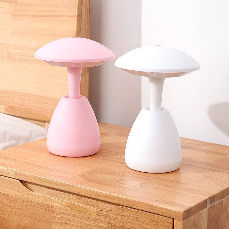 Two bedroom eye protection small night lamps in pink and white, placed on a wooden bedside table. Perfect for cozy ambient lighting.