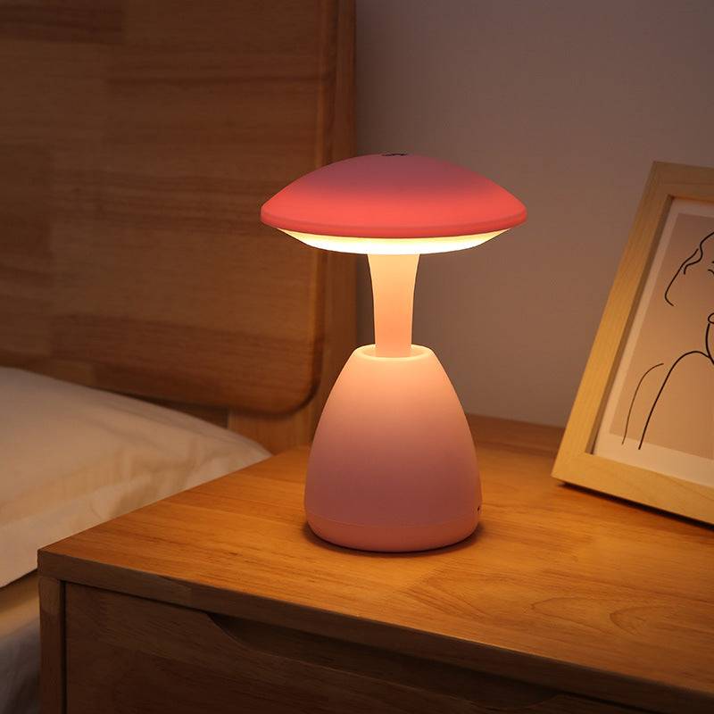 Pink bedroom eye protection small night lamp glowing warmly on a wooden nightstand, creating a soft and relaxing bedroom ambiance.