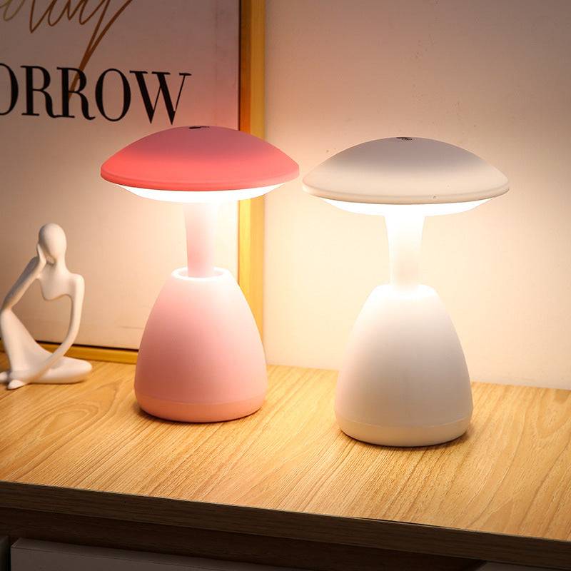 Illuminated pink and white bedroom eye protection small night lamps on a wooden surface, providing warm ambient lighting for a cozy atmosphere.